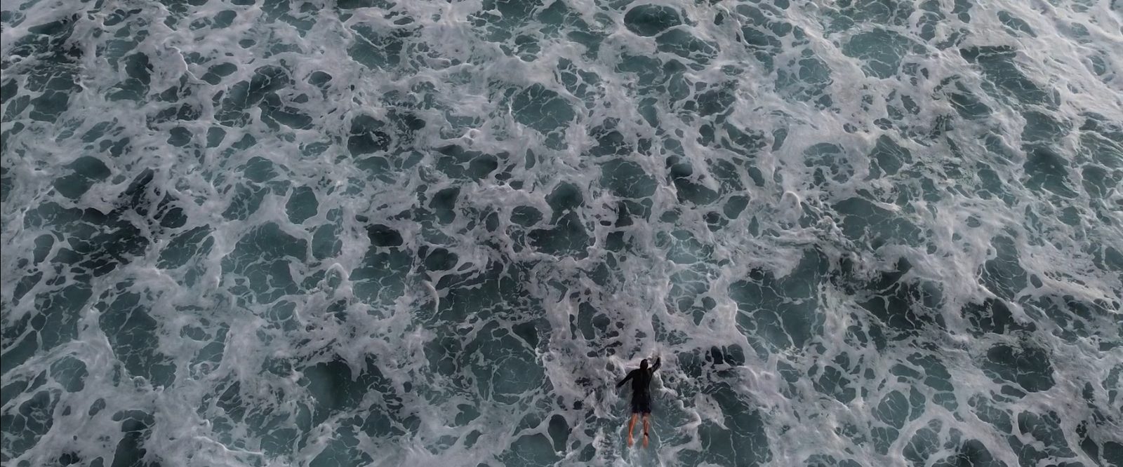 White foam on dark water, seen from above